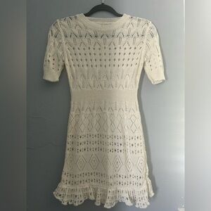 Cream and white knit dress with a stretchy fit .
